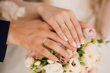 Obraz na płótnie Canvas Wedding bride and groom rings on fingers on a bouquet