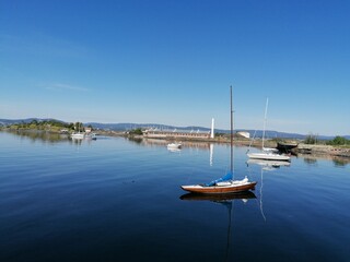 Fototapeta na wymiar Small boats and an island on the lake on a beautiful summer day