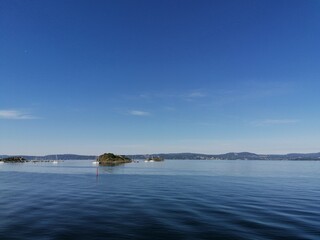 Small boats and an island on the lake on a beautiful summer day