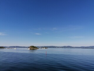 Small boats and an island on the lake on a beautiful summer day