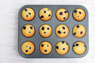 Obraz premium Summer baking - delicious homemade muffins with black currant, just pulled out of the oven