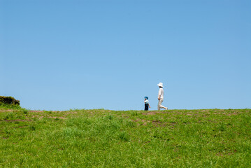Fototapeta premium 丘の上で遊ぶ親子（母親と子ども）