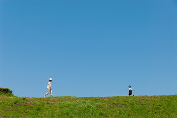 丘の上で遊ぶ親子（母親と子ども）