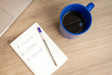 Good morning with coffee. A cup of coffee in blue. Notepad with daily routine. . Sunny.