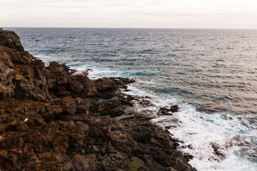 ocean waves hit and crash against stones
