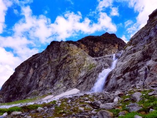 Scenic rock & mountain river stream waterfall with blue sky and clouds beautiful landscape. Mountain creek flowing in spring Karachay-Cherkessia rock, Russia. River stream flow in rock mountain valley