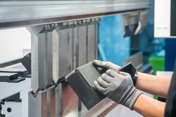 The metalworking operator working with hydraulic bending machine. The automotive sheet metal...