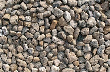 Grey dark colorful pebbles background. Top view. Backdrop made of many small round smooth sea stones.