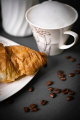 Coffee pouch mockup with croissant and milk in beans on dark romantic blue background. Gold paper clear bag