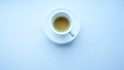 white cup and plate fill with coffee espresso on white table beside window light cool tone top view center stock photo