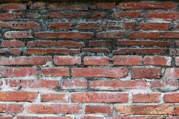 Fototapeta premium Detail of an old brick wall. Upper part in shade, lower lit by the sun.
