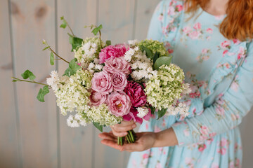 Wedding bouquet at the florist in the hands of roses peonies flowers