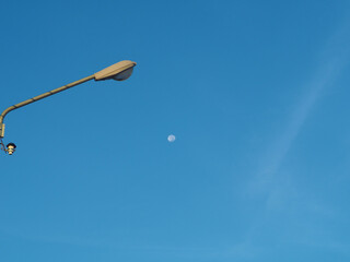 The street light tower on the background is blue sky And there is a small moon in the middle