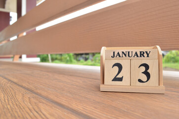 January 23, Number cube with wooden balcony background.