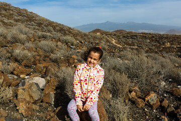 Naklejka premium little girl stands near a cactus on the island of tenerife
