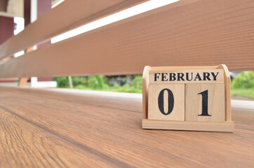 February 1, Number cube with wooden balcony background.