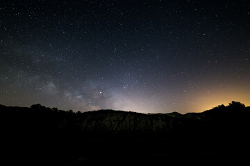Milky way and stars with  light pollution above a mountain