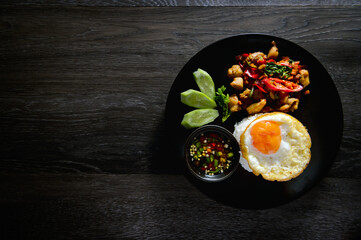 Authentic Thai chicken stir fry with basil sauce, garlic, chili, oyster sauce served with rice, fresh cucumber and fish chili sauce