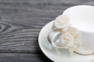 Handmade cup and saucer decorated with polymer clay roses. Jewelry made of white polymer clay.