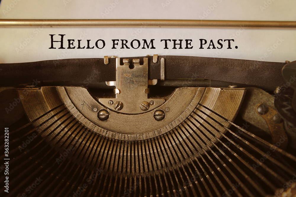 Fototapete hello from the past is typed by an old typewriter on a paper. concept - the result of some long-stan
