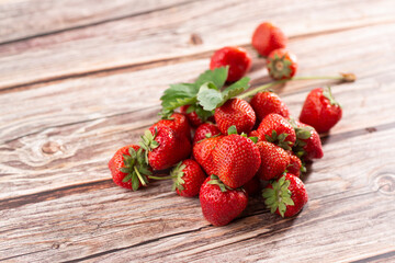 Fresh ripe perfect strawberry on wooden background. Fresh strawberry as texture background. Natural food backdrop with red berries. Strawberries sale in a food market in summer.