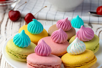French macaroon cookies of bright colors served in white ceramic plate