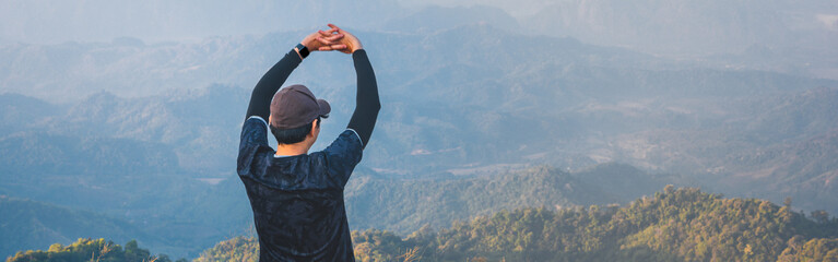 web banner wanderlust and relax in nature from hiker man camping with open arm and embracing nature on top of mountain on spring and summer season