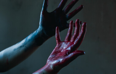 Cosplayer portrays executioner and killer showing bloody hands.