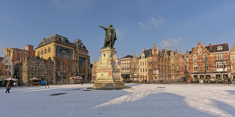 Friday market square, with statue of Jacob van Artevelde, medieval guild houses now housing bars and restaurants on a sunny winter day with snow in Ghent, Flanders, Belgium  - obrazy, fototapety, plakaty