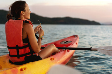 Couple kayaking together. Beautiful young couple kayaking on lake together and smiling at sunset