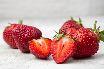 Fresh ripe perfect pieces strawberry on white marble background. Fresh strawberry as texture background. Natural food backdrop with red berries. Strawberries sale in a food market in summer.