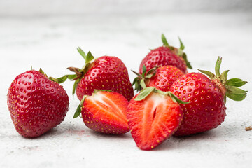 Fresh ripe perfect pieces strawberry on white marble background. Fresh strawberry as texture background. Natural food backdrop with red berries. Strawberries sale in a food market in summer.