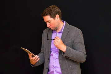 Side view of Middle age Business man uses and works with the pc tablet