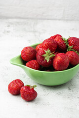 Fresh strawberries in a bowl on marble white table. Fresh nice strawberries. Strawberry field on fruit farm. Heap of Red strewberry on plate close up. Juice strawberry. Strawberry field on fruit farm.
