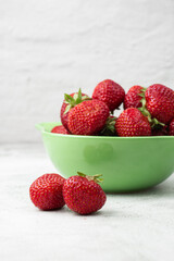 Fresh strawberries in a bowl on marble white table. Fresh nice strawberries. Strawberry field on fruit farm. Heap of Red strewberry on plate close up. Juice strawberry. Strawberry field on fruit farm.