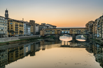Obraz premium Wschód słońca na moście Ponte Vecchio nad rzeką Arno we Florencji, Włochy.