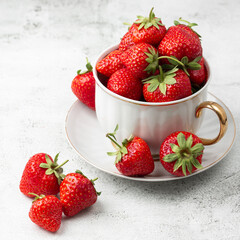 Fresh strawberries in a white cup on marble white table. Fresh nice strawberries. Strawberry field on fruit farm. Heap of Red strewberry on plate. Juice strawberry. Strawberry field on fruit farm.