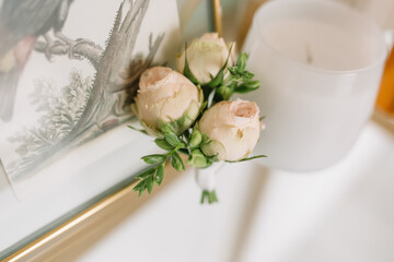 Small roses on a table a groom’s boutonniere at a wedding