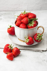 Fresh strawberries in a white cup on marble white table. Fresh nice strawberries. Strawberry field on fruit farm. Heap of Red strewberry on plate. Juice strawberry. Strawberry field on fruit farm.
