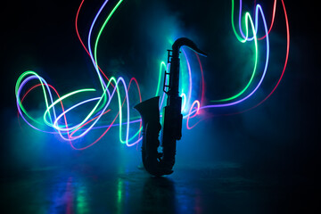Alto gold sax miniature with colorful toned light on foggy background. Saxophone music instrument...