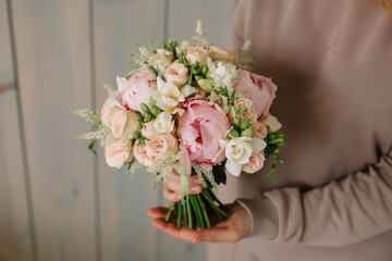 Wedding bouquet of delicate roses and peonies for the bride