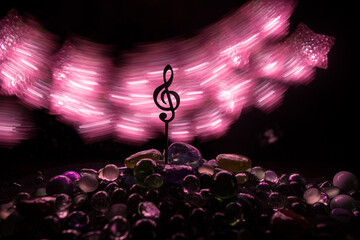 Musical symbol treble clef stainless steel miniature with colorful toned light on foggy background....