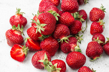 Fresh ripe perfect strawberry on white marble background. Fresh strawberry as texture background. Natural food backdrop with red berries. Strawberries sale in a food market in summer.