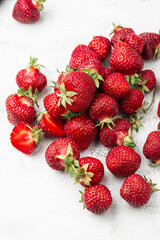 Fresh ripe perfect strawberry on white marble background. Fresh strawberry as texture background. Natural food backdrop with red berries. Strawberries sale in a food market in summer.