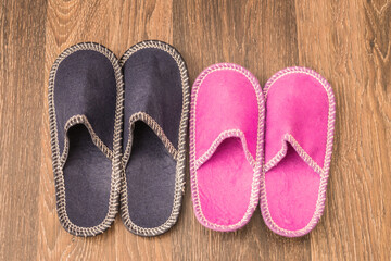 Two pairs of colorful slippers are on the floor. There are male and female slippers in the bedroom. The concept of harmonious relations of men and women.