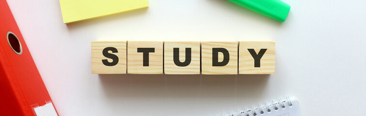 Wooden cubes with word STUDY on the office desk.