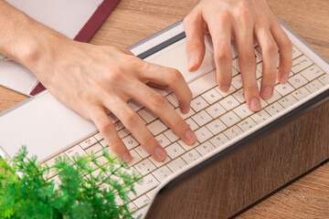 Fototapeta na wymiar closeup top view of hands typing on computer