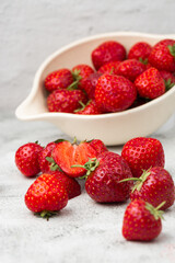 Fresh strawberries in a bowl on marble white table. Fresh nice strawberries. Strawberry field on fruit farm. Heap of Red strewberry on plate close up. Juice strawberry. Strawberry field on fruit farm.