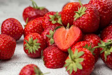 Fresh ripe perfect strawberry on white marble background. Fresh strawberry as texture background. Natural food backdrop with red berries. Strawberries sale in a food market in summer.
