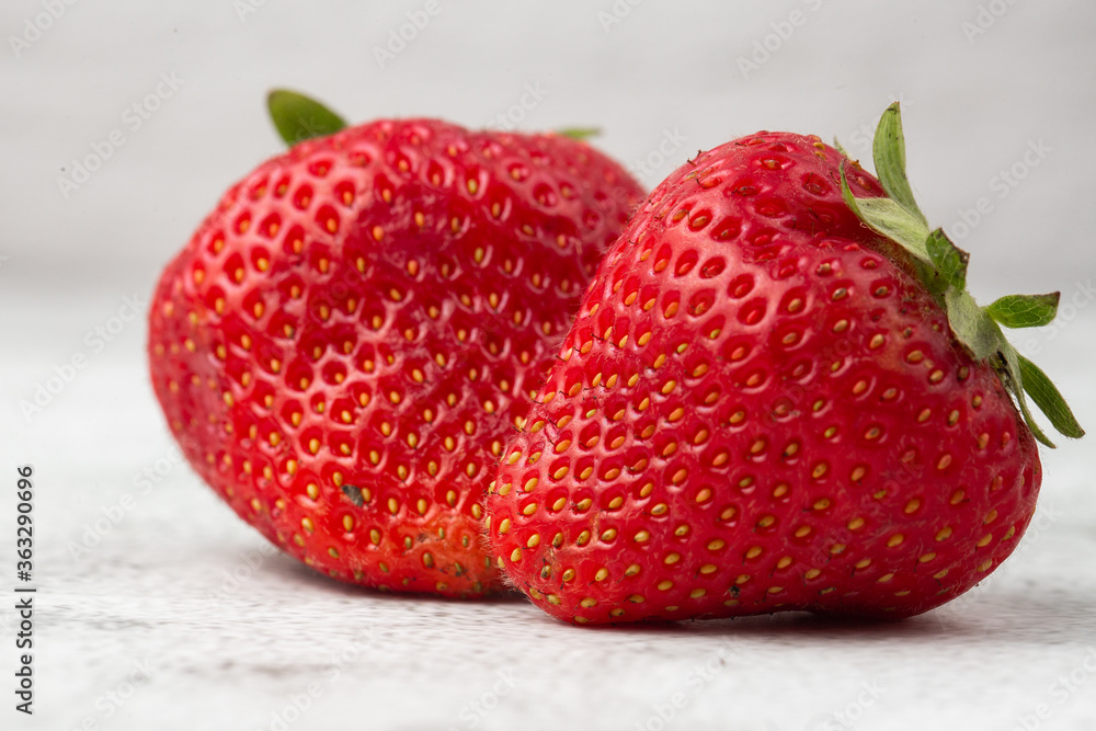 Wall mural fresh ripe perfect strawberry on white marble background. two fresh strawberry isolated. natural foo